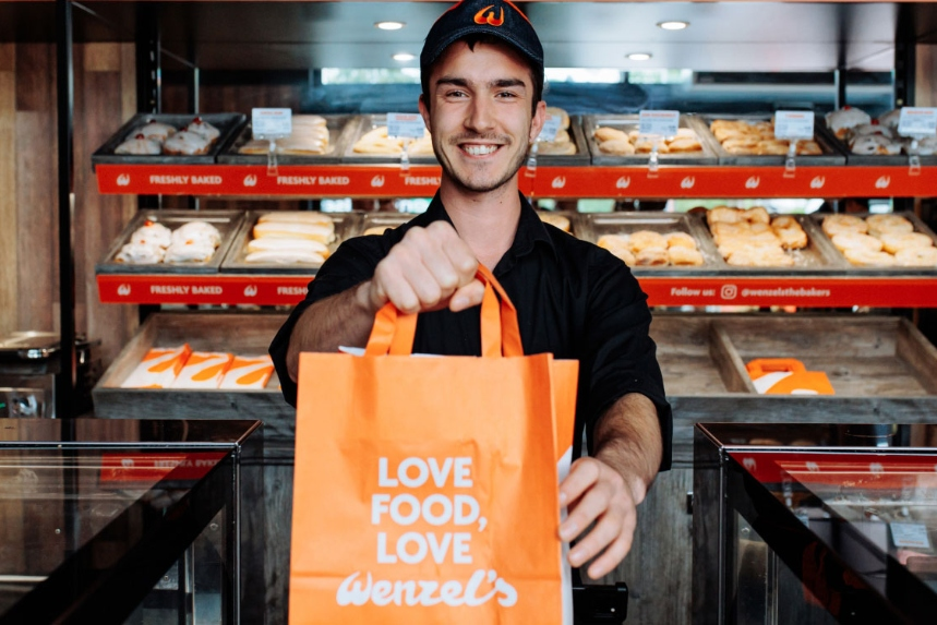 Team member holding a Wenzel's takeaway bag